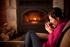 woman-drinks-coffee-by-gas-fireplace